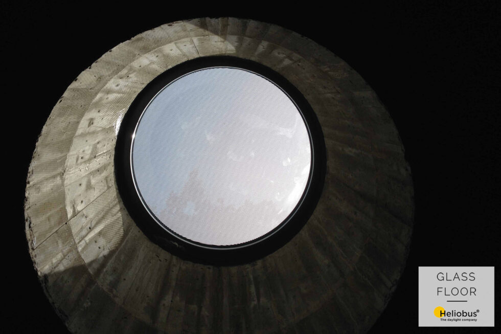 Kruhový světlík Glassfloor v moderním provedení s pohledovým betonem vytváří architektonický prvek spojený s vizuální estetikou. Prostor získává jedinečný charakter díky kombinaci elegantního designu a betonové textury, což představuje pečlivě promyšlený architektonický koncept.