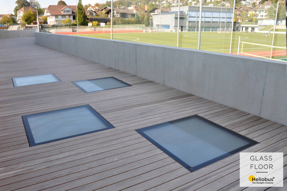 Dřevěná pochozí terasa s integrovanými pochozími skly k prosvětlení místnosti denním světlem pod terasou.